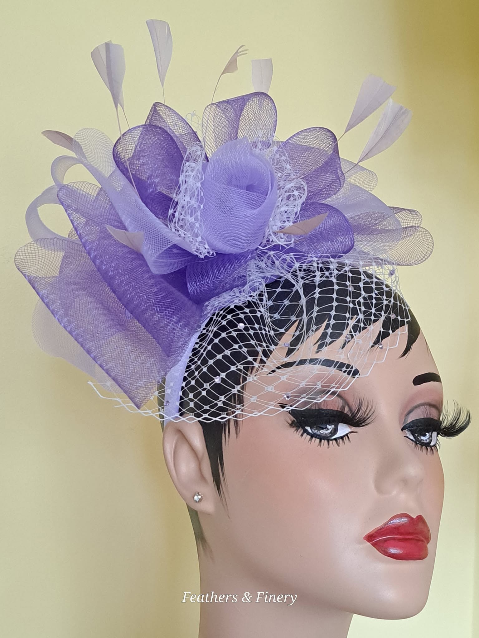 Purple fascinator with netting and feather details